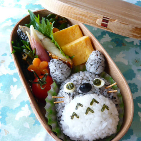 Rice ball shaped like a character in a wooden lunchbox.