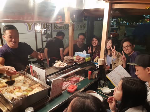 Vendor preparing food at an outdoor food stall.