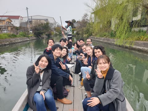 Group of people posing on a boat in a canal.