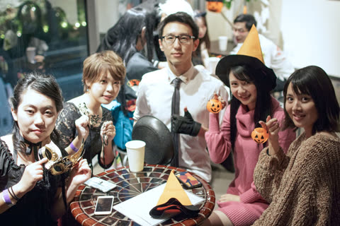 Group of costumed people posing at indoor table.