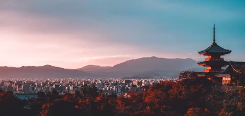 Sunset view of a city and mountains from a pagoda.
