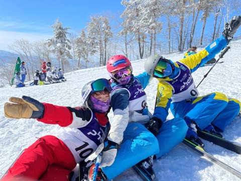 Three skiers pose on snowy slope.