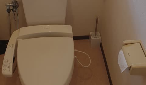 White toilet with electronic controls in a bathroom.
