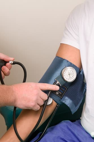 Person's blood pressure being measured with a sphygmomanometer.