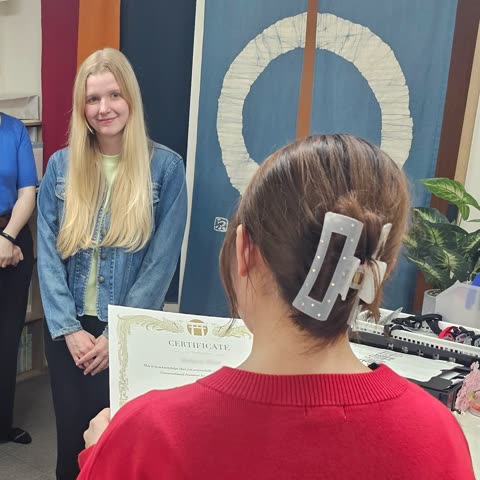 Woman receives certificate in classroom.